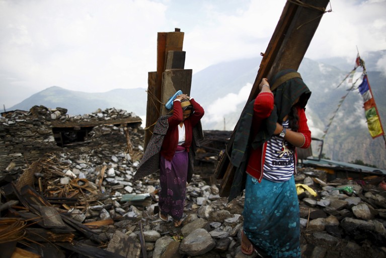 People salvage wood from house destroyed by the Gorkha earthquake, Nepal.