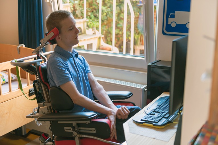A young ALS patient playing computer games with the help of his electronic wheelchair