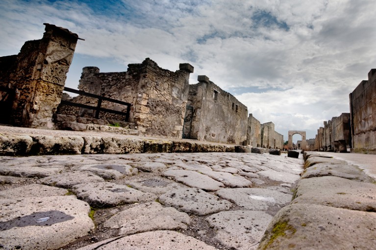 Stone-paved street in Pompeii leading to Roman gateway