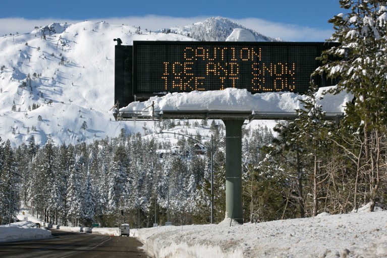 An electronic sign on a road in South Lake Tahoe warns of snow and ice