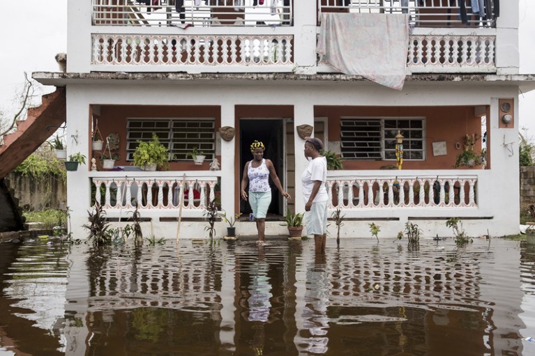 Residents wade through flood waters at their home days after Hurricane Maria made landfall in Puerto Rico