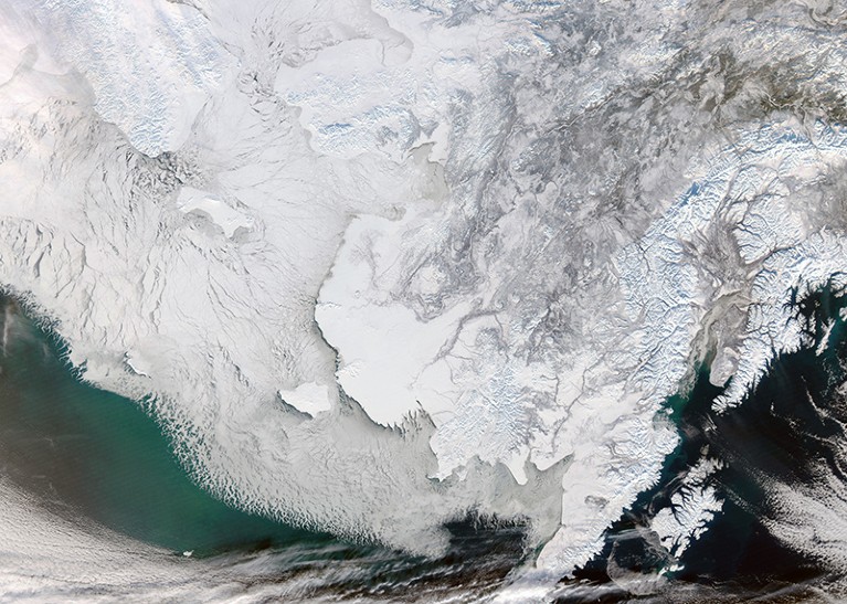 Satellite image of the Bering Strait, covered in ice, with part of Russia on the left and Alaska on the right..