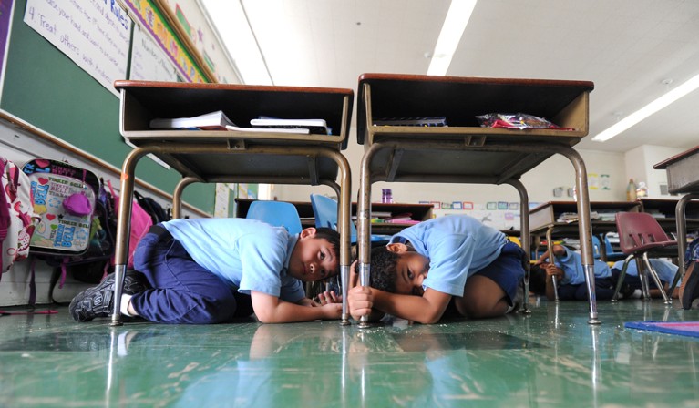8th-grade students in Torrance, California, take cover under their school desks during an earthquake drill