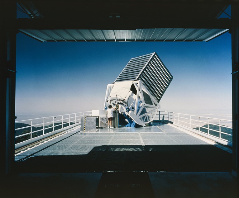 An astronomer works on the main telescope of the Sloan Digital Sky Survey.