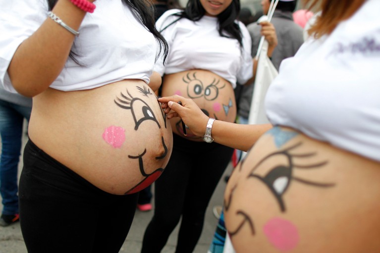 Pregnant women paint their bellies with smiling faces to celebrate "Healthy Maternity Week"