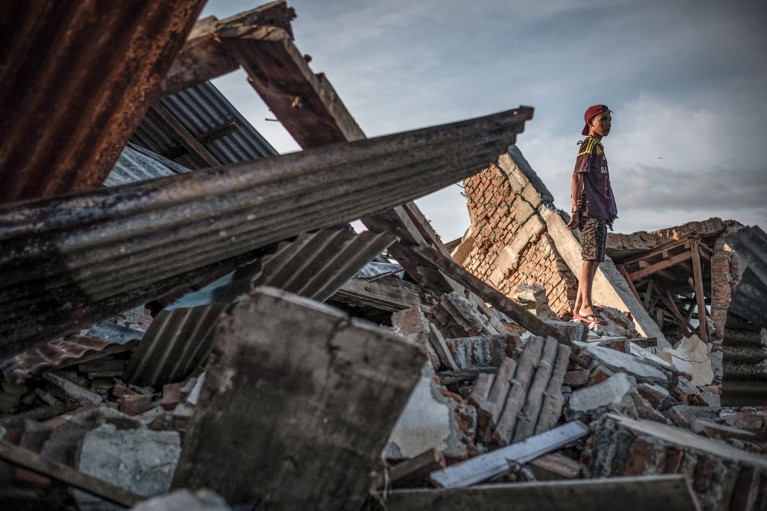 A resident stands on the ruins of a building that was destroyed by the earthquake on Palu, Indinesia