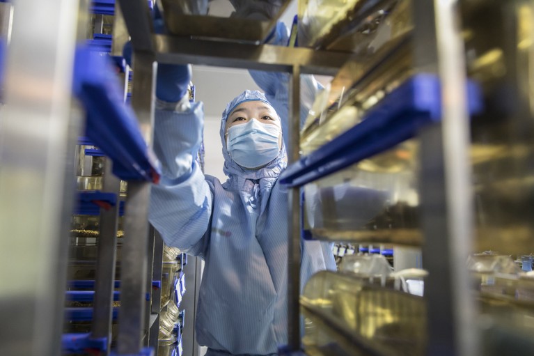 A technician loads mice containers onto a rack at a Cyagen Biosciences Inc. facility in China