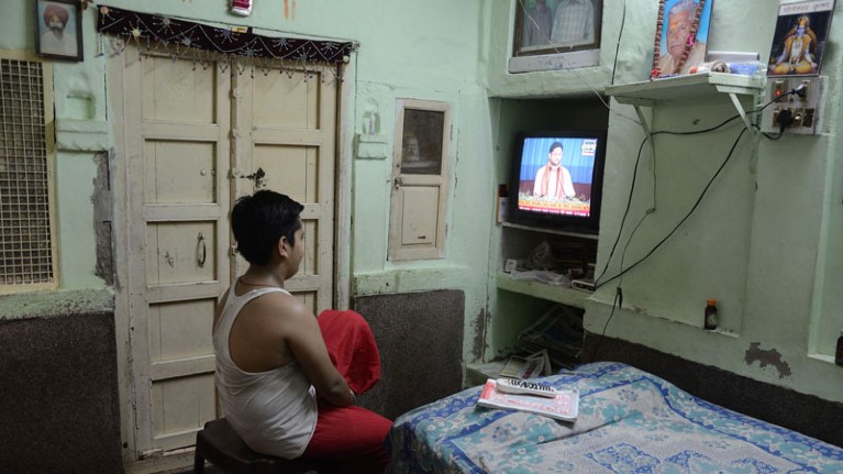 A man uses a television in his bedroom in Jodhpur, India.