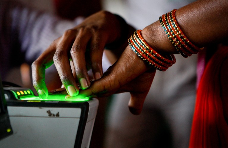A migrant farm worker, scans her fingerprints to register to receive a national identity card and number in New Delhi