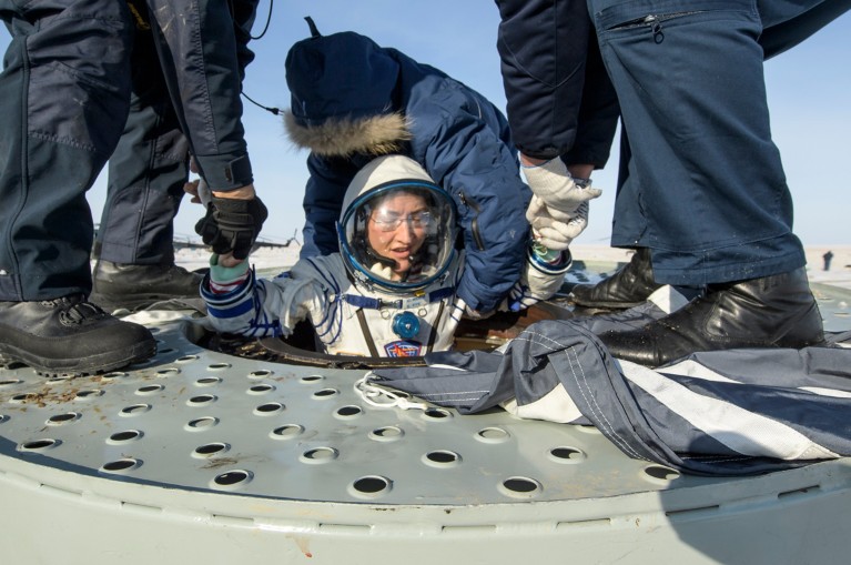 NASA astronaut Christina Koch is helped out of the Soyuz MS-13 spacecraft moments after landing
