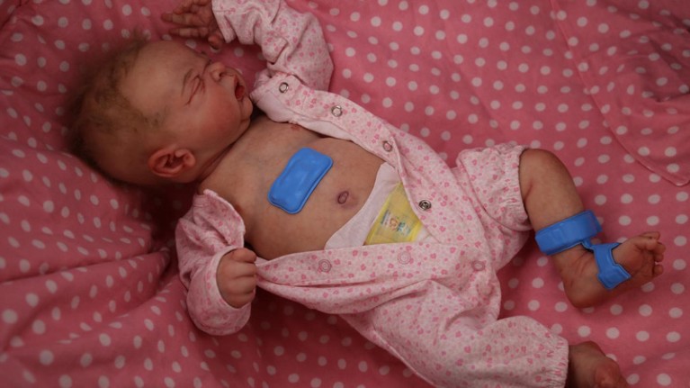 Wireless sensors are displayed on a model neonate in the lab.