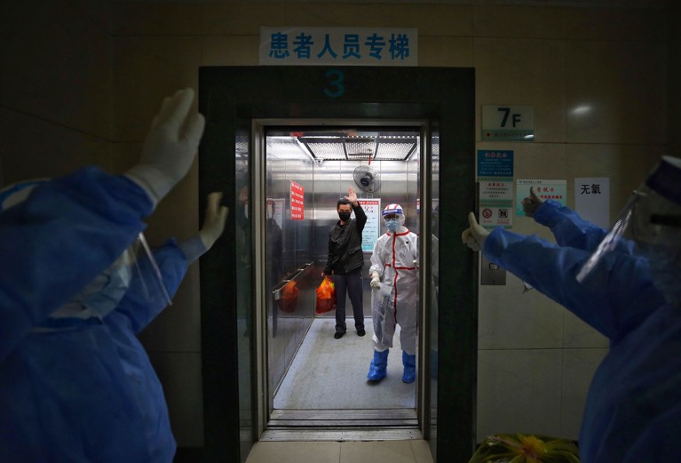 Medical staff wave goodbye to a recovered COVID-19 patient at the Red Cross Hospital in Wuhan