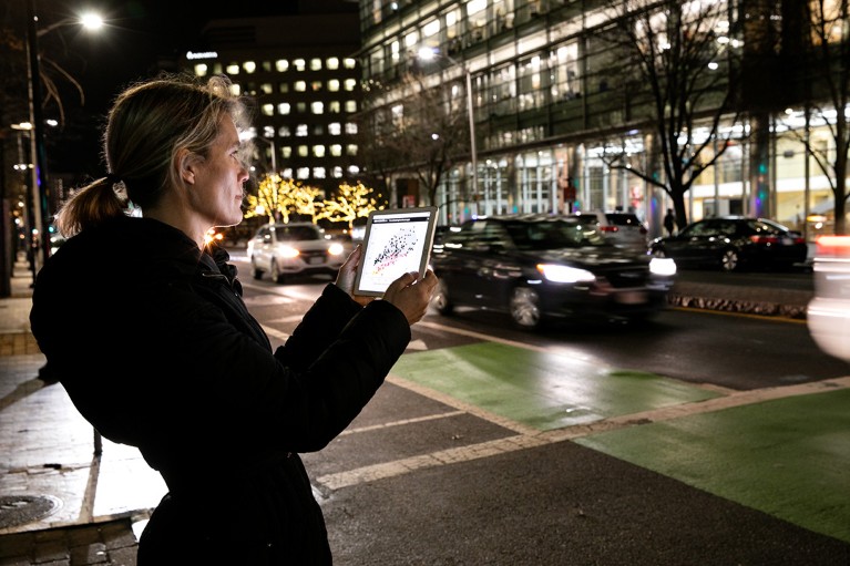 Jessika Trancik uses the CarbonCounter app on a tablet on the street in Cambridge