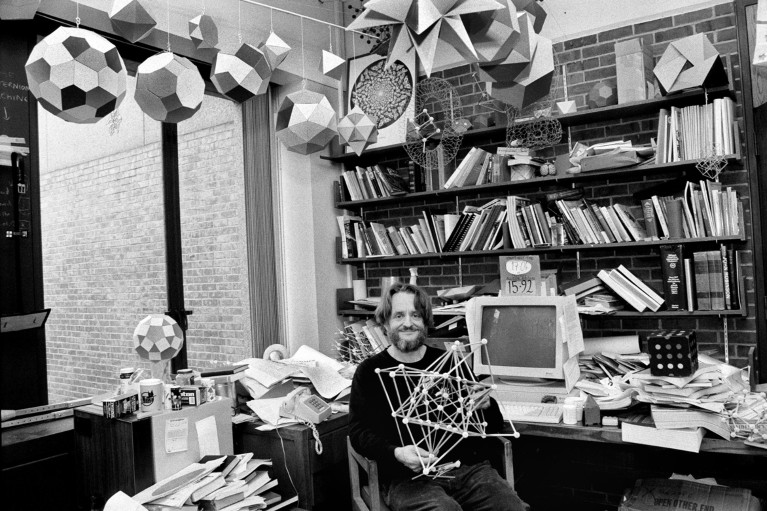 John Horton Conway sitting in his office in 1993 surrounded by books and geometric models