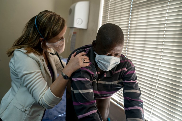 A doctor listens to the lungs of a patient with tuberculosis with a stethoscope