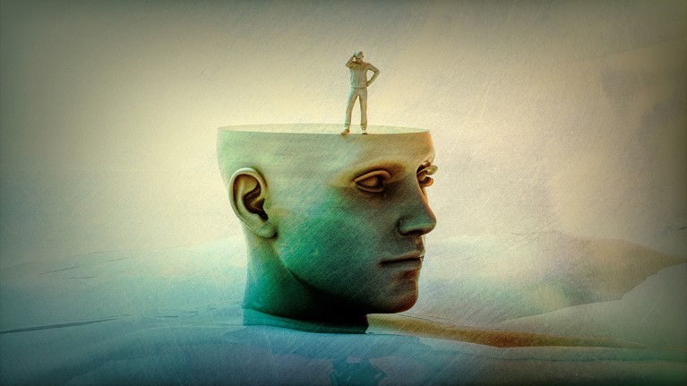A small human figure stands on a stylized human head with a flattened top like a table