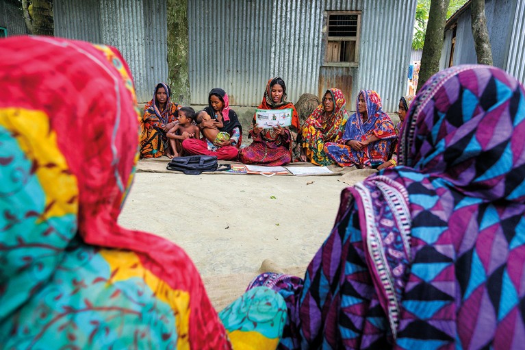 Bangladeshi women sit on the floor at a meeting about contraception