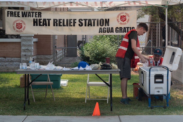 Men fill a cooler with water at a heat relief station in Phoenix, Arizona