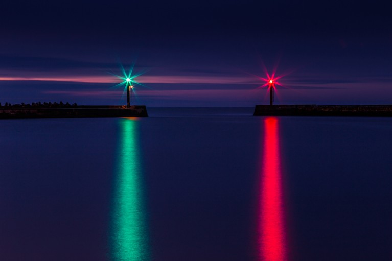 Green and red lights reflecting on the sea