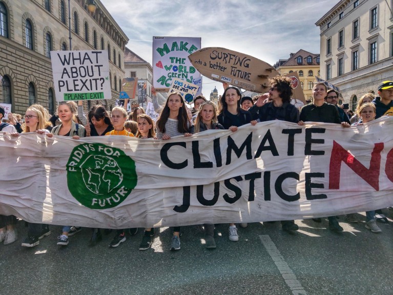 Demonstrators march with placards and banners reading 'Fridays for Justice' and 'Climate justice now', Munich 2019