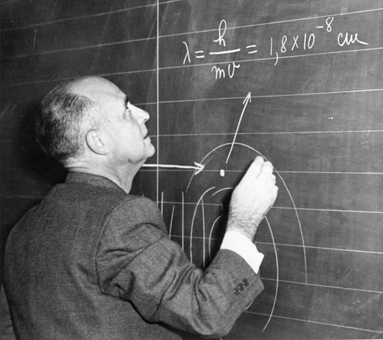 Atomic scientist and Nobel prize winner Professor Enrico Fermi writes on a chalkboard during a lecture in Milan, Italy.