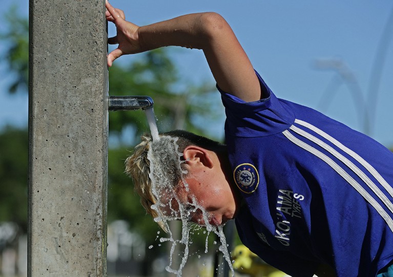 A man cools off with water during a hot summer day in Vicente Lopez, near Buenos Aires, Argentina, during an intense heat wave.