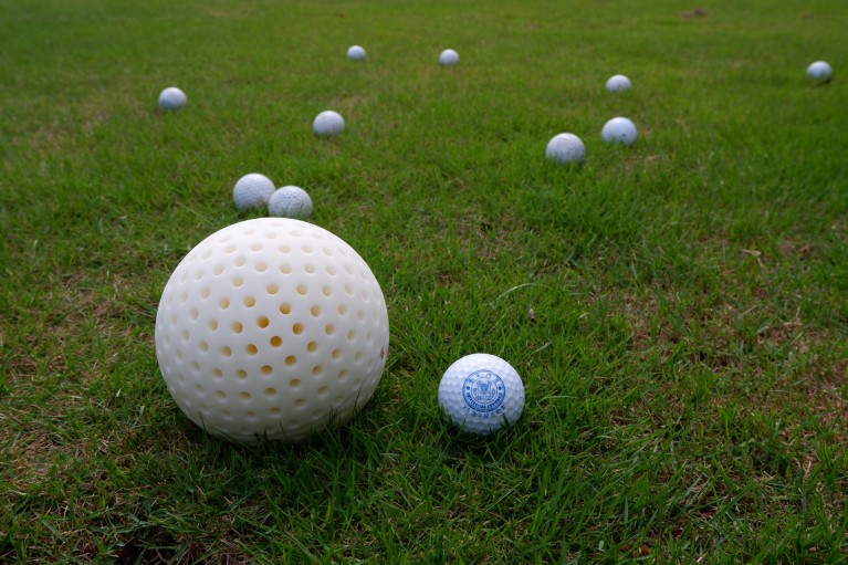 The fabricated illusion shell sits on a golf course surrounded by golf balls
