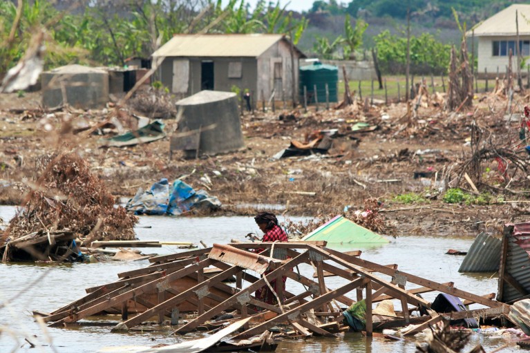 汤加诺穆卡岛的一名居民正在清理海啸后的废墟