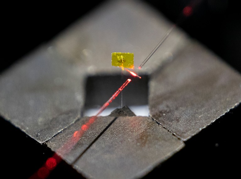 Diamagnetically levitated force sensor with a thin yellow film on top.