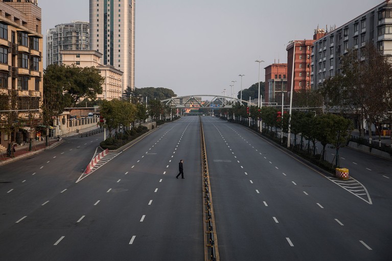A man crosses an empty highway road on 3 February 2020 in Wuhan, Hubei province, China.