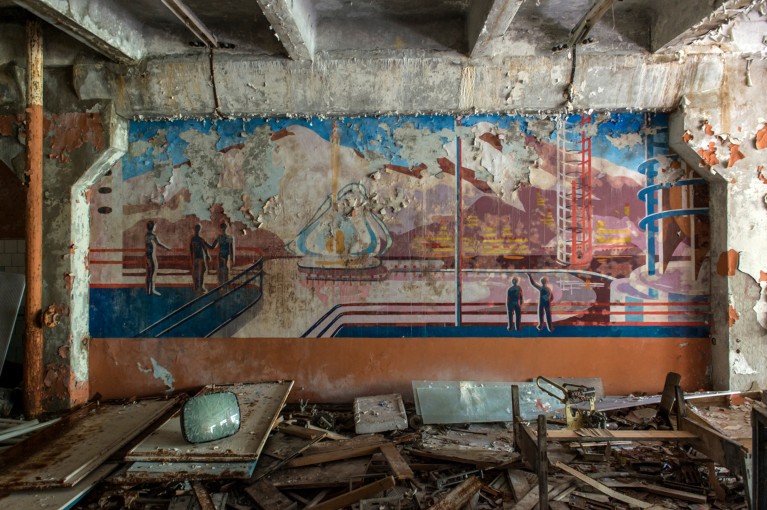 Broken screens and furniture lay around a faded mural of Soviet propaganda images at the Duga radar facility in Chernobyl
