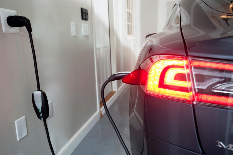 A Model S Tesla being charged in a home garage
