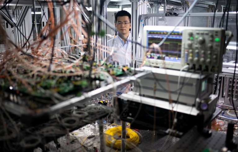 Portrait of Chao-Yang Lu with his protoype Jiuzhang quantum computer.