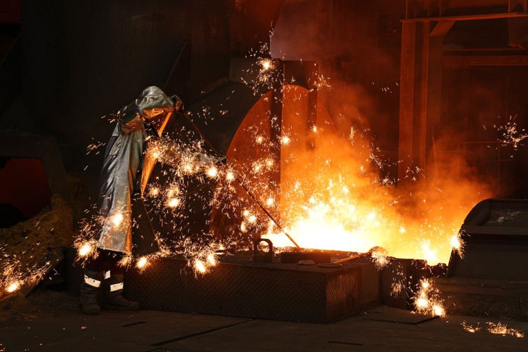 Sparks fly as a worker takes a sample of molten iron flowing from a blast furnace at the Thyssenkrupp Steel Europe steelworks.