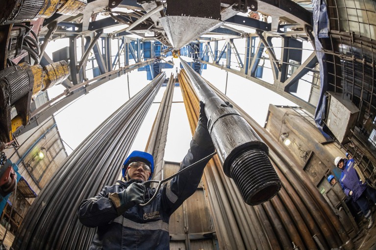A worker guides drilling pipes at a gas drilling rig on a resource base for the Power of Siberia gas pipeline.
