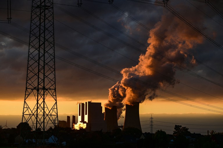 A power station during golden hour with dramatic dark clouds above .