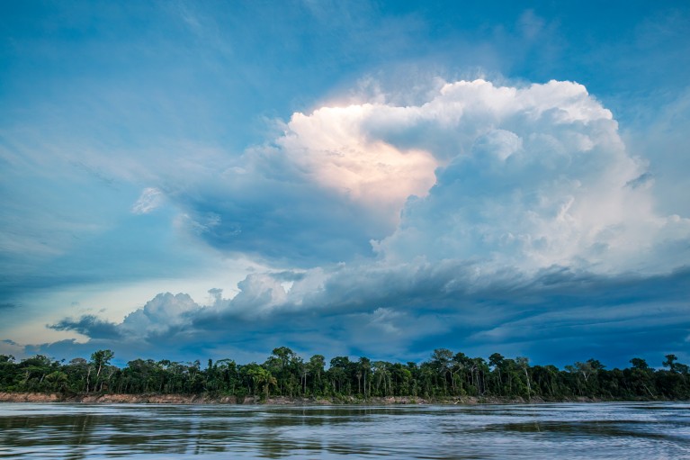Wide angle view of a large storm cloud over the Amazon river and rainforest