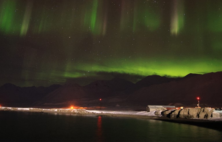 Aurora borealis, aka northern lights, at Ny-Alesund science village in polar night of mid-January Kongsfjorden.