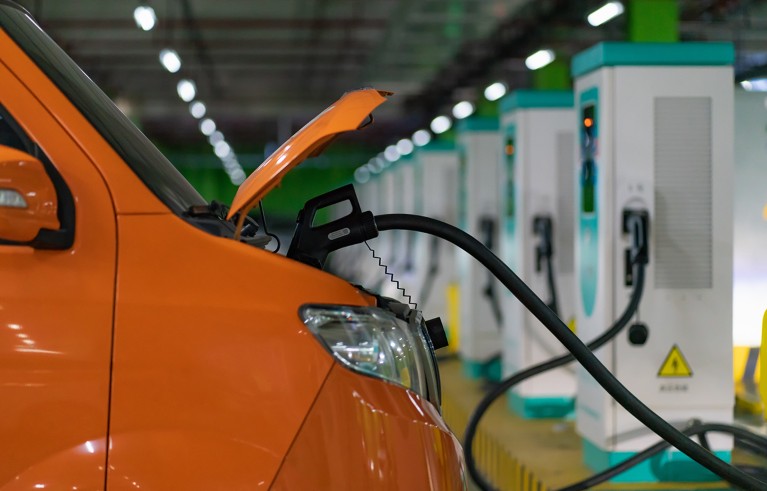 The charging station in the underground garage is full of electric cars being charged.