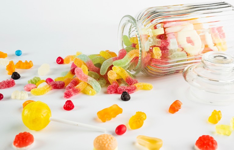 Close-up of candies in jar on table.