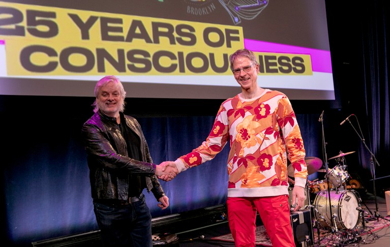 David Chalmers (L) shakes hands with Christof Koch (R) onstage at the Association for the Scientific Study of Consciousness meet
