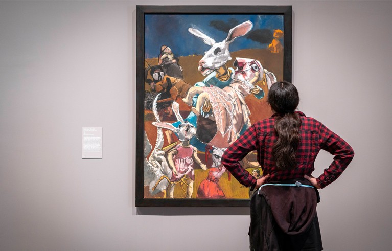 Visitor contemplating Paula Rego’s painting War 2003, displayed at the Tate Modern, London.