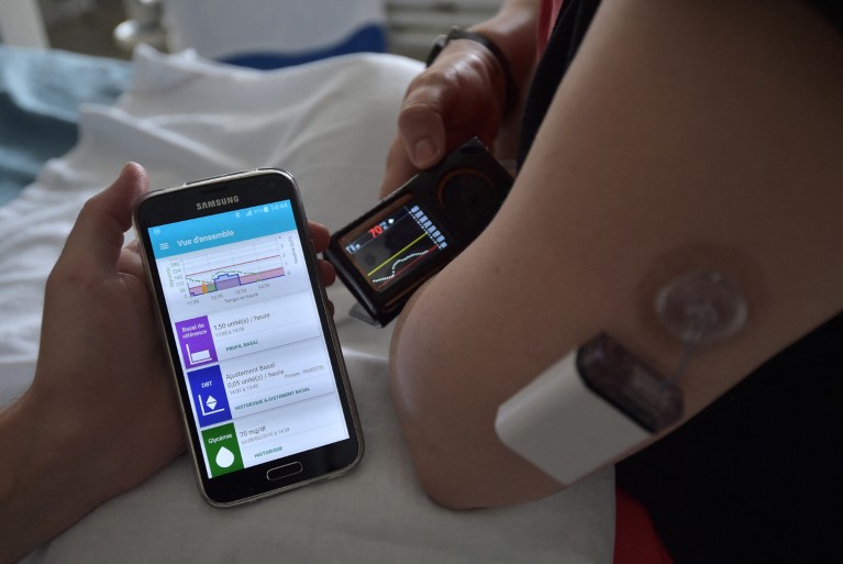 Close-up of a diabetic person holding a smartphone showing an insulin app