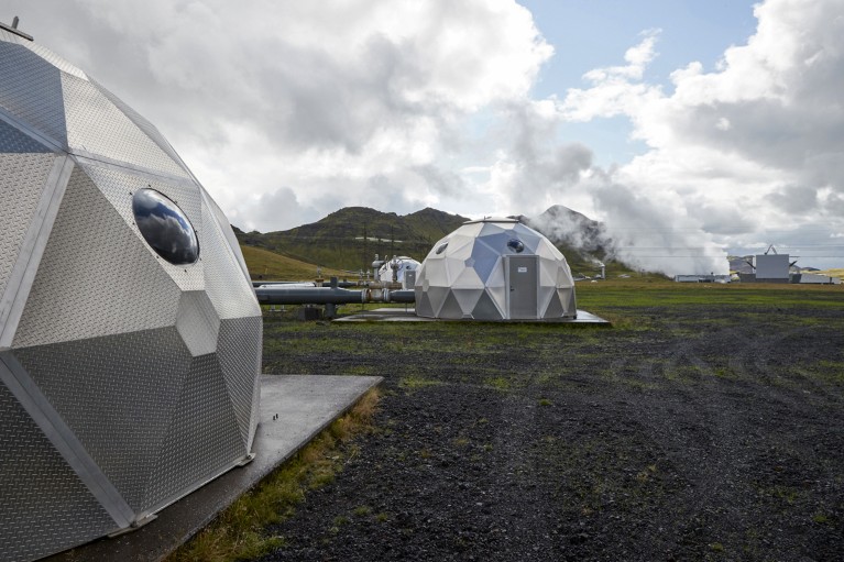 A close-up of silver pods used for storing carbon dioxide underground in Iceland on a cloudy day
