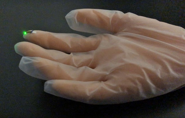 Image showing the EL of PeLEDs drawn on diverse substrates, such as a vinyl glove.