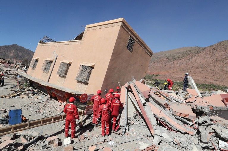 Rescue team members work among the rubble of a collapsed building.
