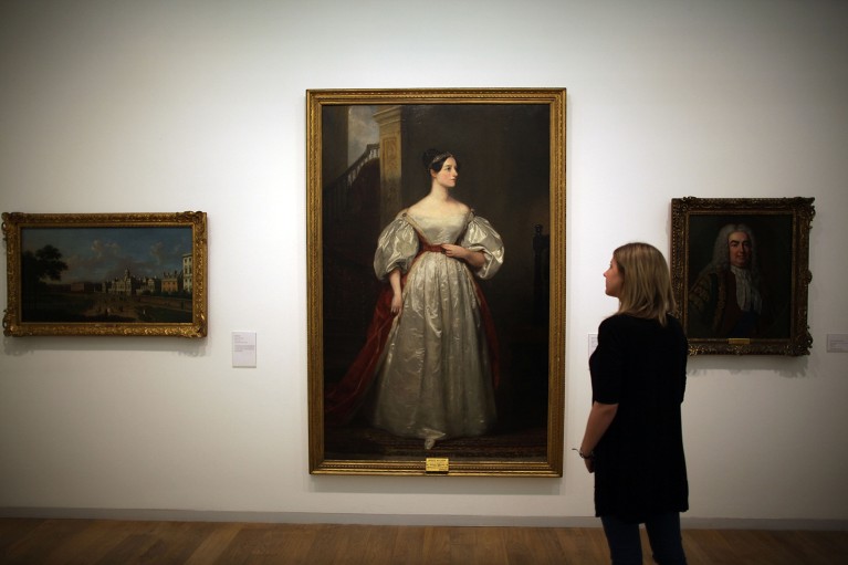 A gallery employee looks at a painting of Ada Lovelace