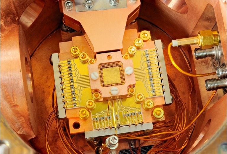A chip surrounded by a copper enclosure and gold wire mesh to prevent build-up of static charge.