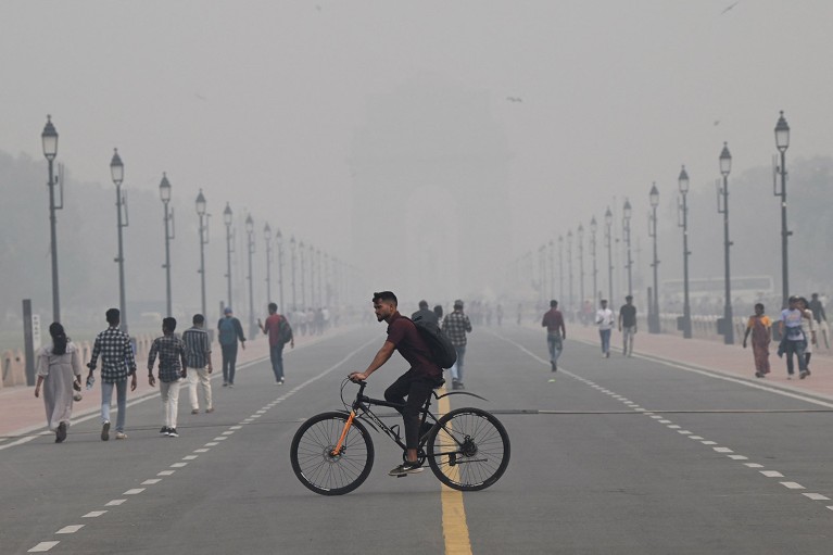 People walk along the Kartavya Path near India Gate amid heavy smog conditions in New Delhi.