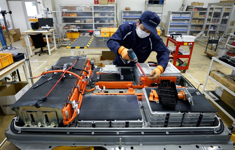 An employee disassembles a used lithium-ion electric vehicle battery.